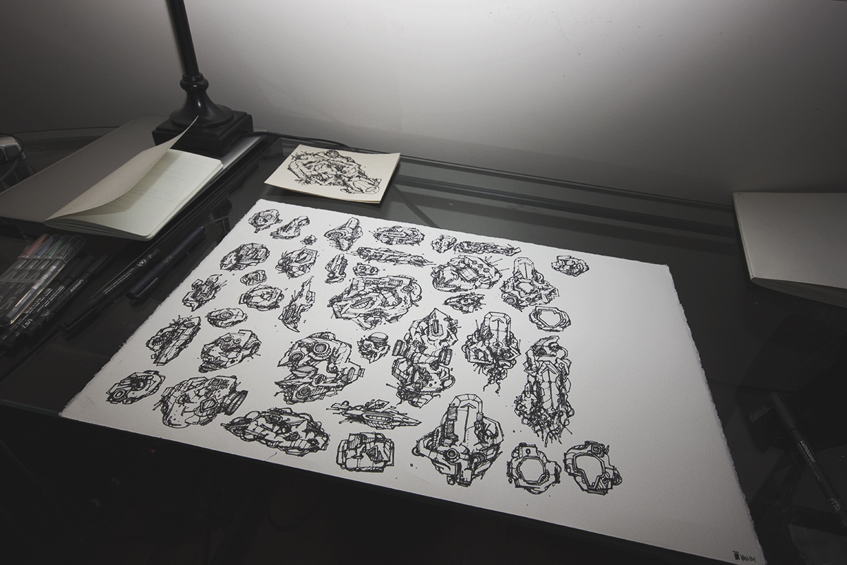 Photo of a large sheet of paper on a desk, covered in ink drawings.
